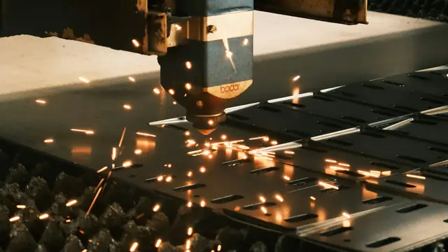 Máquina de corte industrial em operação, com faíscas sobre chapa metálica.